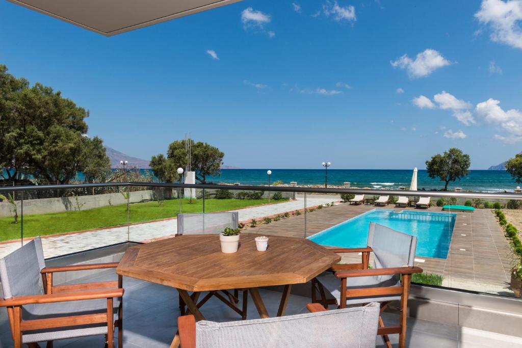 基萨莫斯Niovi Seaside Suites的海景阳台上的桌椅