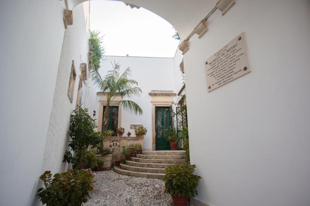CursiVilla De Pietro的走廊上设有楼梯和盆栽植物