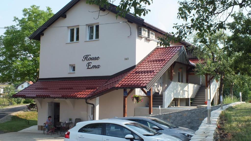 格拉博瓦茨艾玛旅馆的前面有一辆汽车停放的白色房子