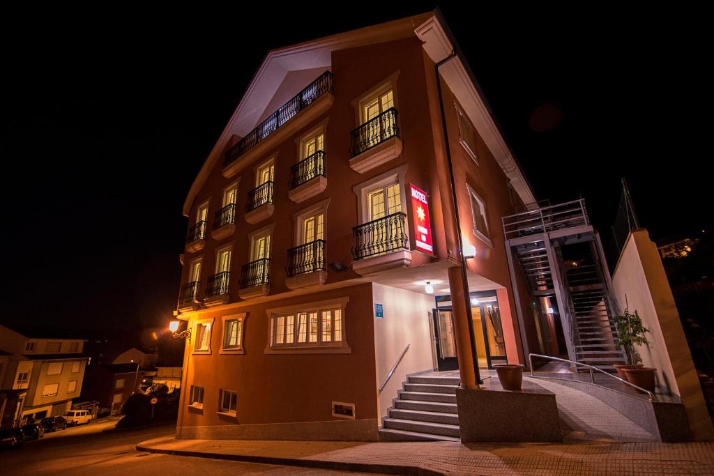 奥巴尔克伊洛Hotel Porto do Barqueiro的一面有红色标志的建筑物