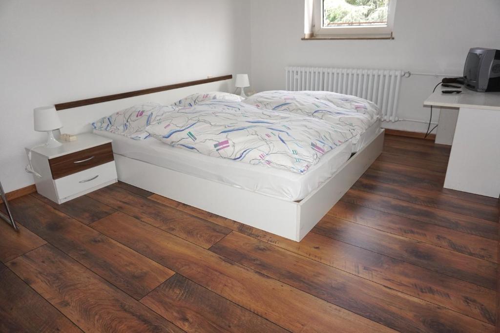 杜塞尔多夫阿图斯酒店的一间卧室配有一张床,铺有木地板