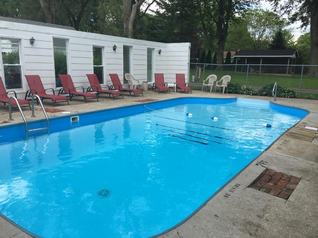 休伦湖种植园汽车旅馆的周围设有红色椅子的大型蓝色游泳池