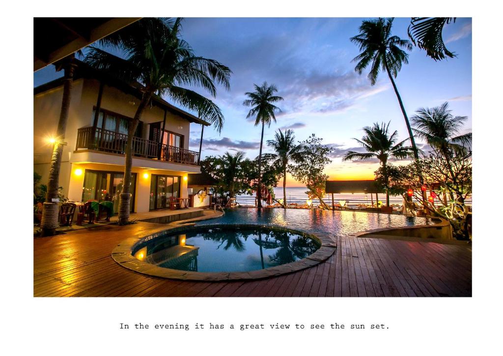 象岛麦克度假酒店的棕榈树建筑前的游泳池