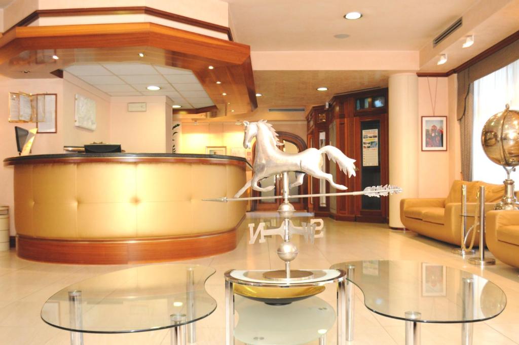 马格拉蒙黛尔酒店的一间玻璃桌的房间,上面有一只白马