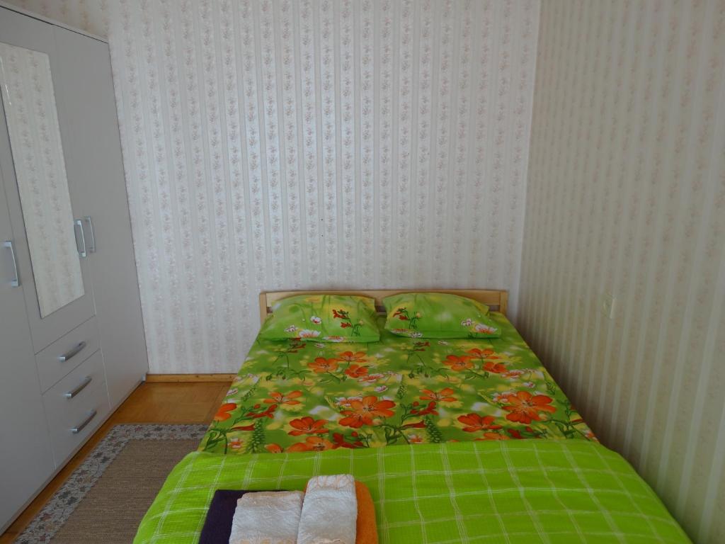 派尔努弗兰德伦帕匹尼杜公寓的一间小卧室,配有一张带绿色棉被的床