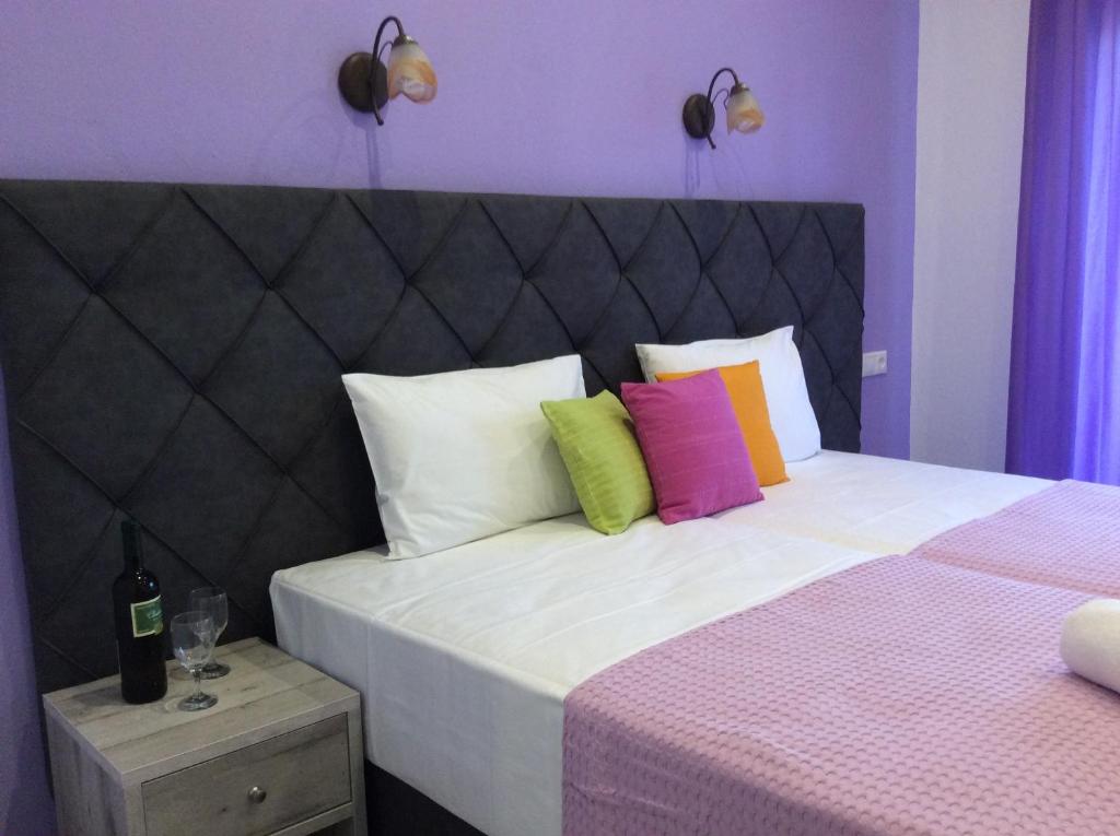 斯基亚索斯镇Studios Nopi-Zoi的一间卧室配有一张带色彩缤纷枕头的大床