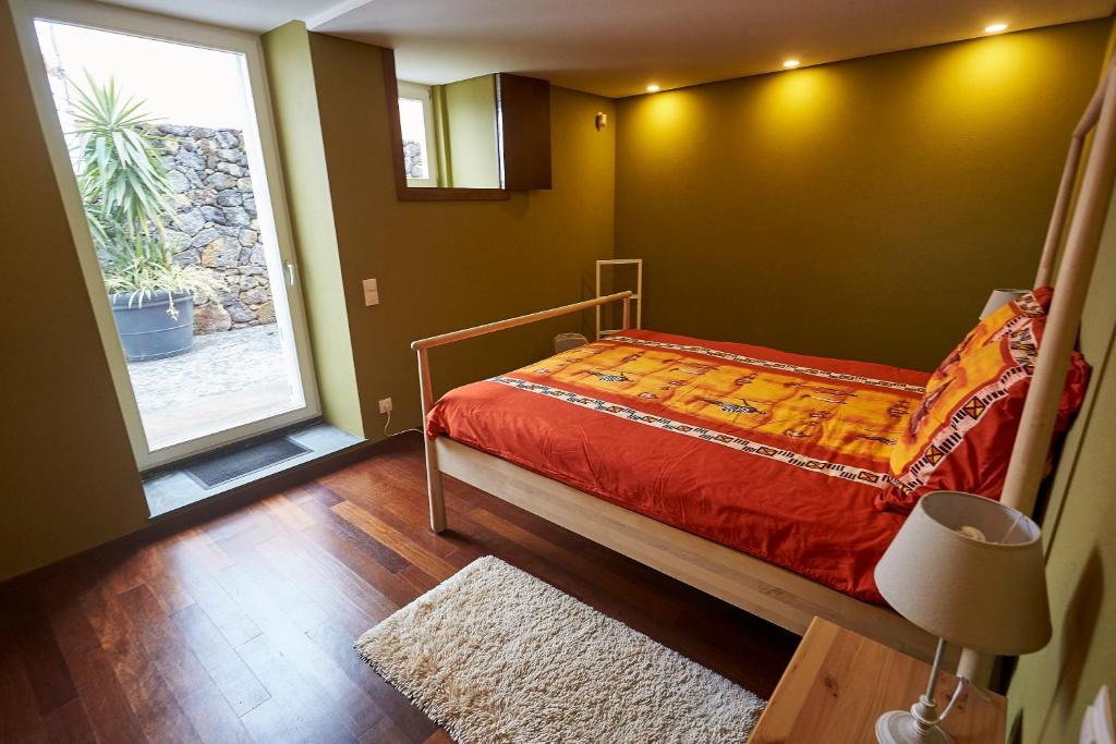 Porto JudeuCasa do Vizinho的一间卧室设有一张床和一个大窗户
