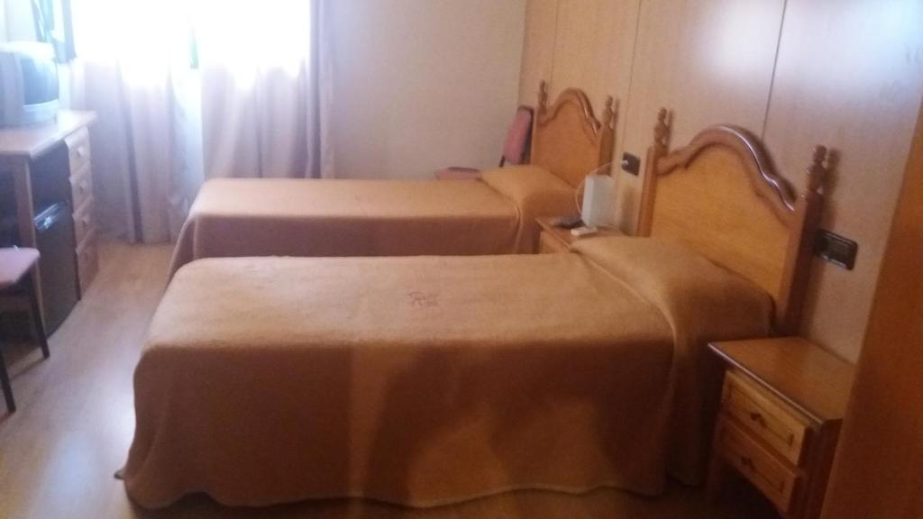 马斯萨内特德拉塞尔瓦Hostal Bonaterra的小型客房配有两张床和一张桌子。