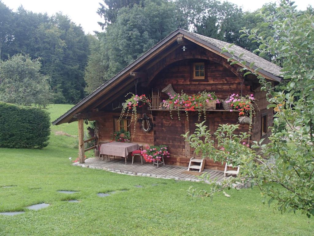 圣保罗恩查拉Le Grenier的小木屋配有桌子和鲜花