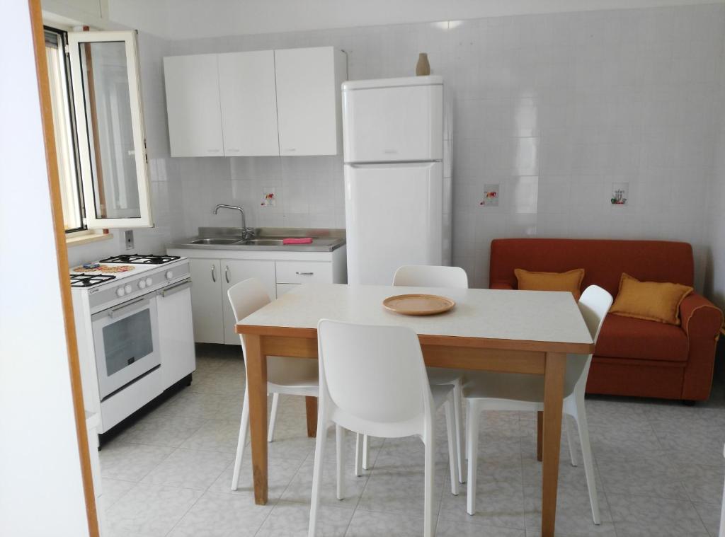 萨尔维Salento Mare Sabbioso的厨房配有白色的桌子和白色的椅子