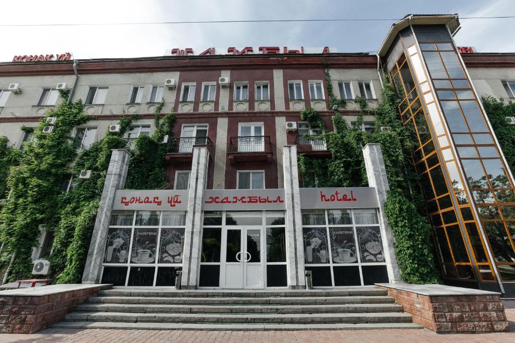 塔拉兹Hotel Zhambyl的前面有楼梯的建筑