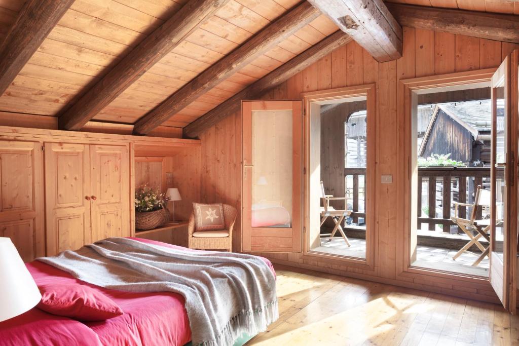 绍里斯Albergo Diffuso Sauris in Sauris Di Sopra的卧室配有一张床铺,位于带木墙的房间内