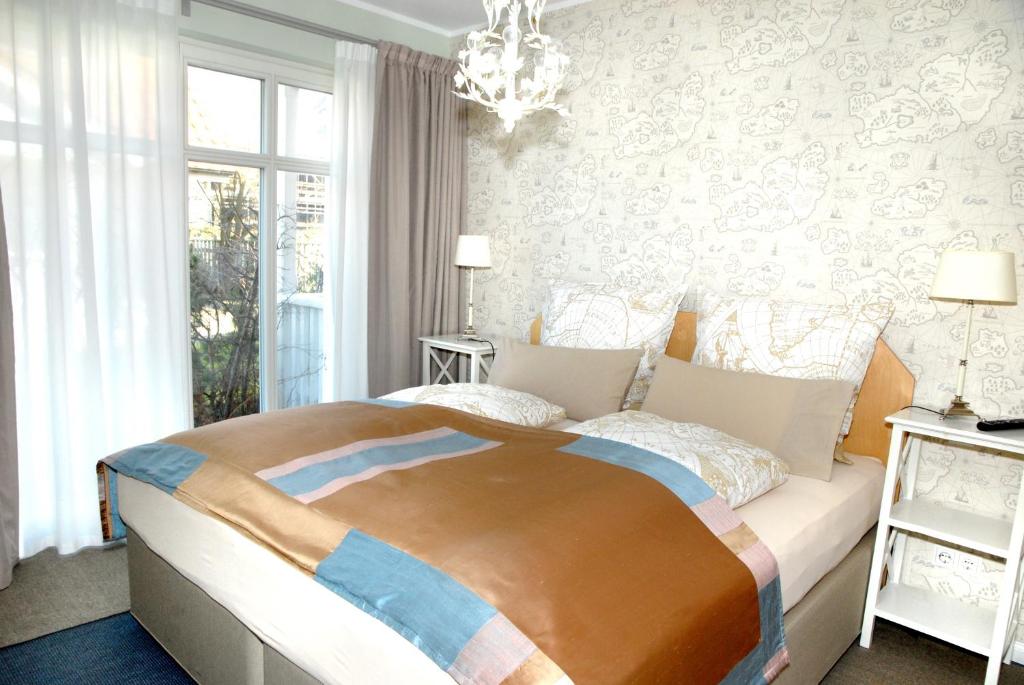 蒂门多弗施特兰德路易莎公寓式酒店的一间卧室配有一张大床和一个吊灯。