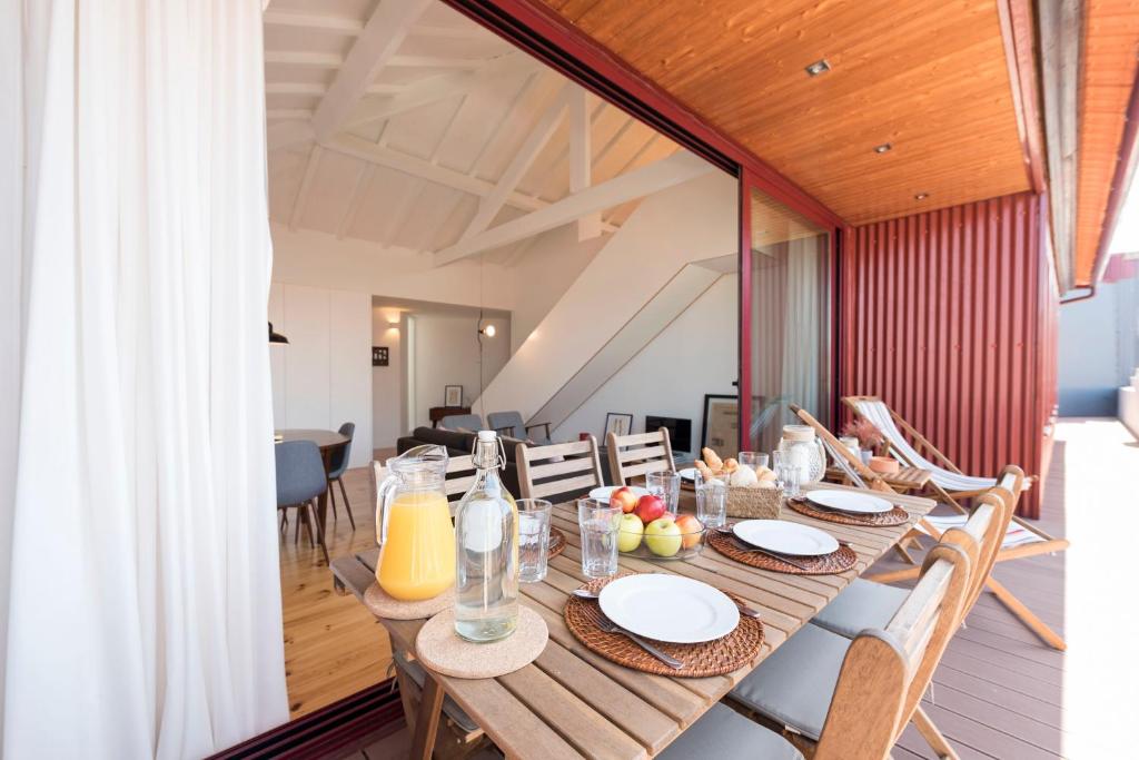 波尔图LovelyStay - Top Floor Balcony Apartment的一间带木桌和椅子的用餐室