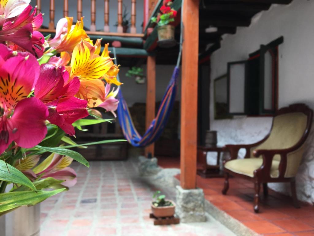 蒙圭Hotel Otti Colonial的椅子旁边装满五颜六色花的花瓶