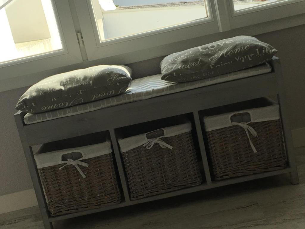 拉康提内勒Mes Ptits Apparts的两扇窗户旁的一张长凳和两个枕头