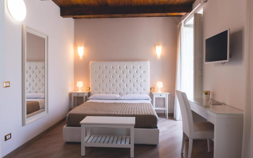 雷焦卡拉布里亚Fata34 Luxury B&B的一间卧室配有一张床、一张书桌和一面镜子