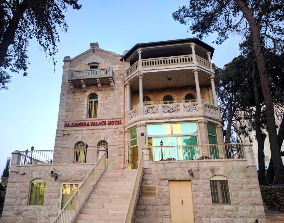 拉马拉Alhambra Palace Hotel Suites - Ramallah的一座古老的房子,前面有楼梯