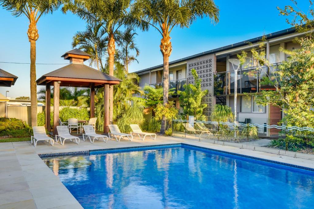 卡伦德拉金色海滩酒馆奈特卡普汽车旅馆的一个带凉亭和棕榈树的游泳池