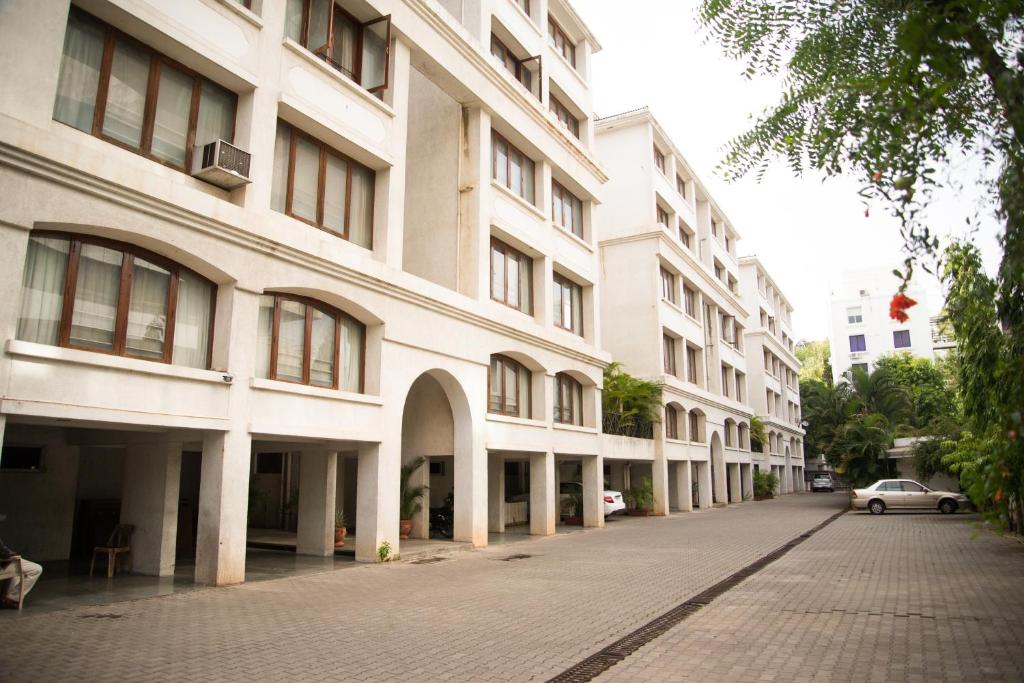 浦那Hermitage Suites Koregaon Park Garden & Terrace Room的一个大建筑前的一条空的街道