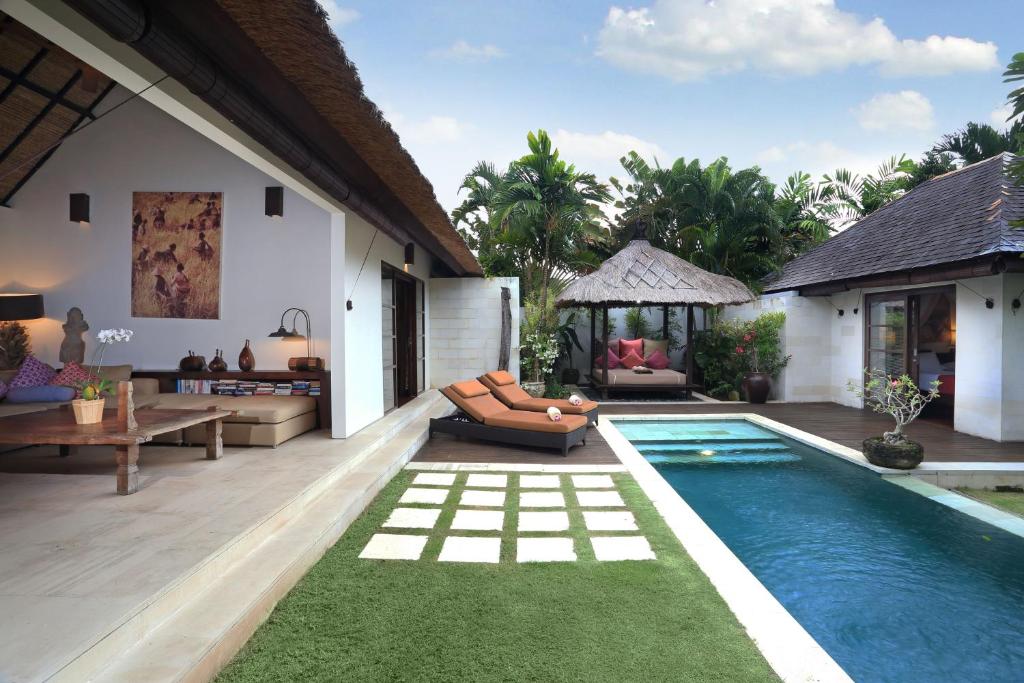 塞米亚克巴厘阿斯里别墅酒店的一个带游泳池和别墅的后院