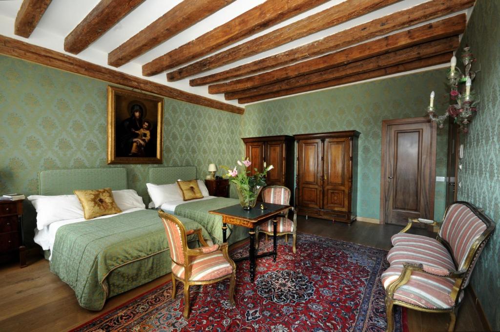 威尼斯丽都雷莱爱博蒂酒店的卧室配有一张床和一张桌子及椅子