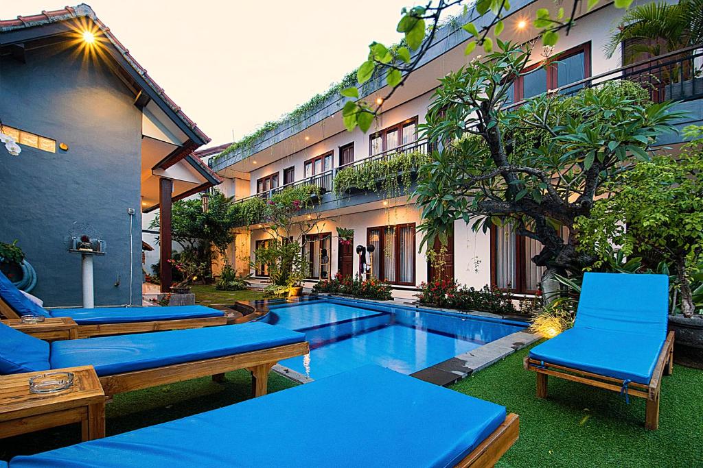 坎古巴厘岛满月旅馆的一个带游泳池和椅子的度假胜地和一座建筑