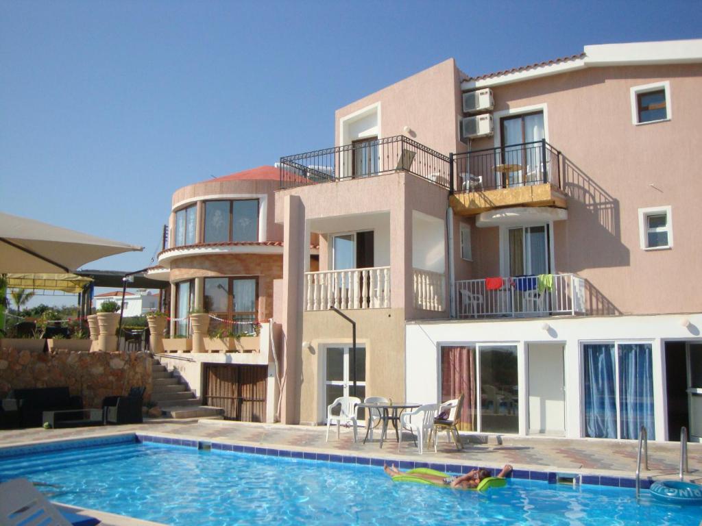 珊瑚湾Bella Rosa hotel Cyprus的房屋前有游泳池的建筑