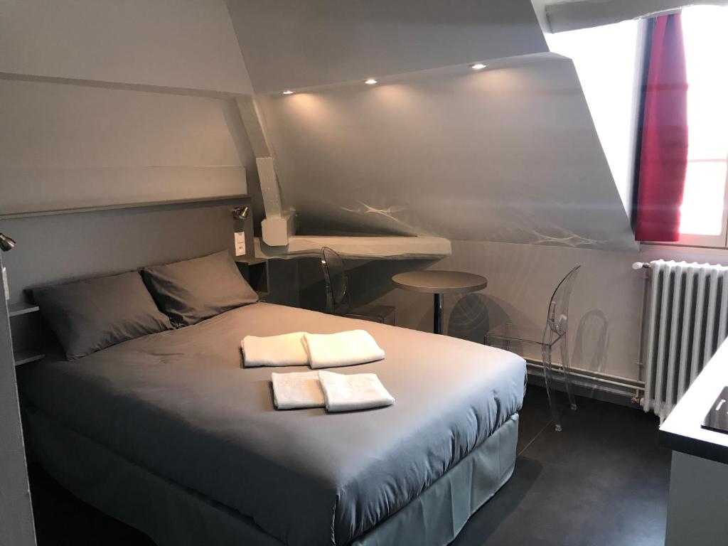 特鲁瓦SmartAppart Troyes的一间卧室配有一张床,上面有两条毛巾