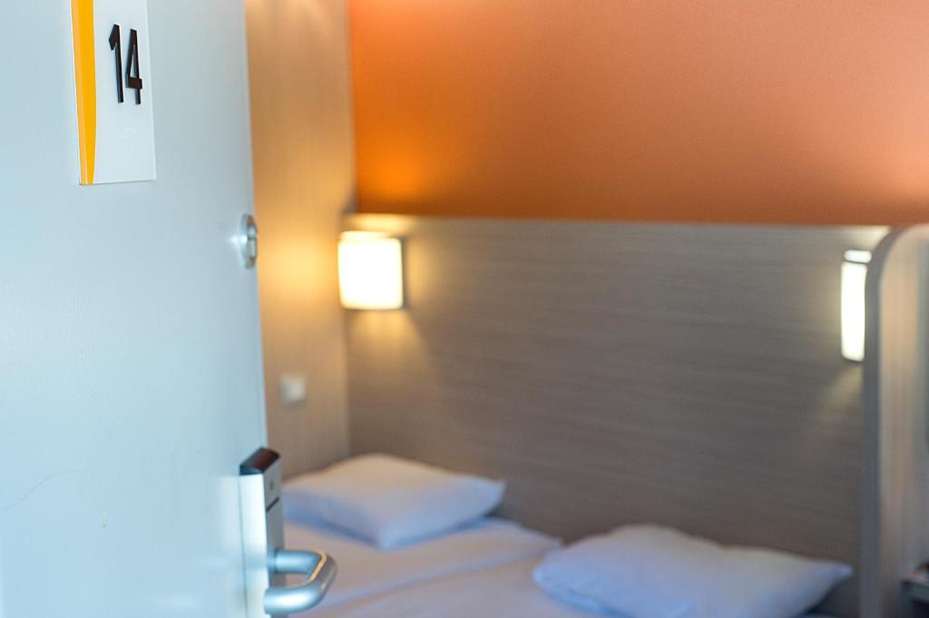 奥比埃普瑞米尔克雷蒙费兰德奥比耶尔经典酒店的卧室配有2个白色枕头