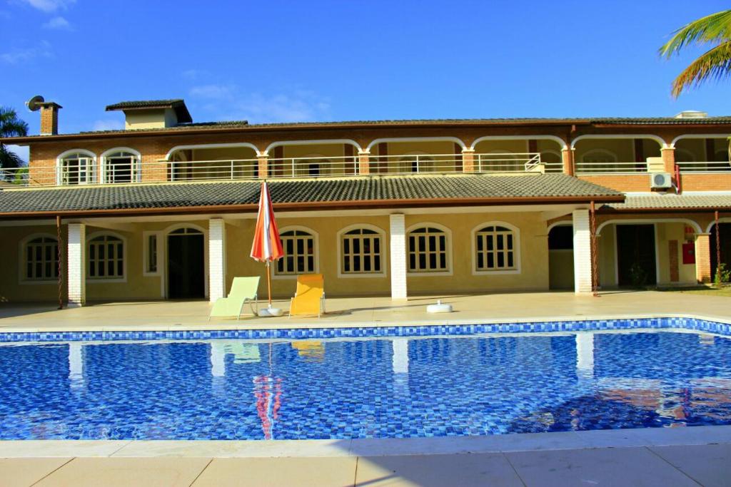 卡拉瓜塔图巴Pousada Porto do Rio的一座房子前面设有游泳池