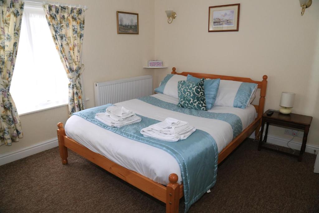 艾恩布里奇Ladywood House Bed and Breakfast的一间卧室配有带毛巾的床