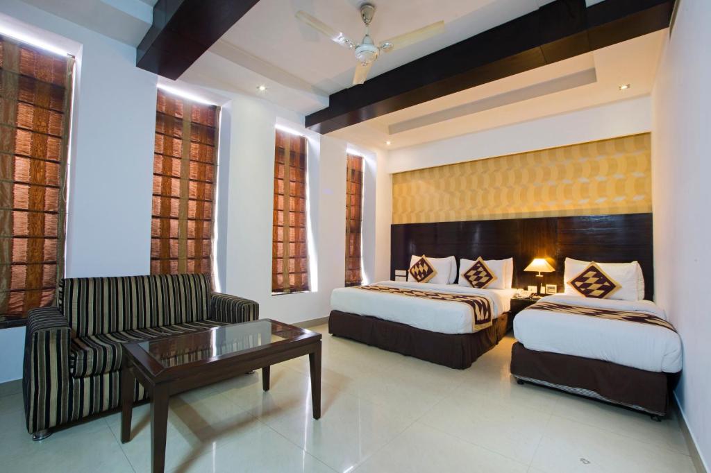 新德里Hotel Krishna - By RCG Hotels的酒店客房,设有两张床和一张沙发
