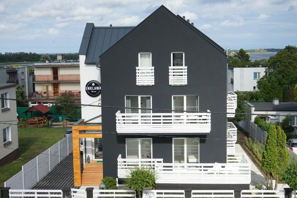 弗瓦迪斯瓦沃沃Enklawa Nord Bałtycki Chillout House的黑房子,设有白色阳台