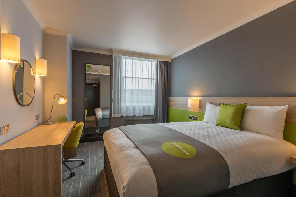 卢顿Thistle Express London Luton的酒店客房设有一张大床和一张书桌。
