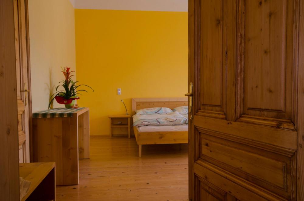 卡姆普河畔舍恩伯格Papperl a' Pub的一间卧室设有一张床和黄色的墙壁