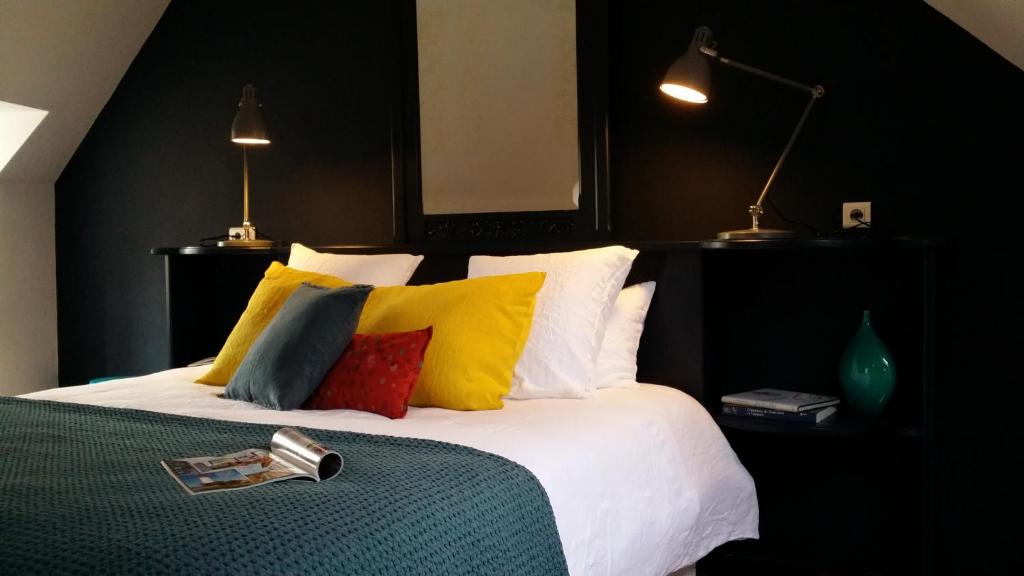 Pont-CroixLe 29 d'à côté的一间卧室配有一张带色彩缤纷枕头的大床