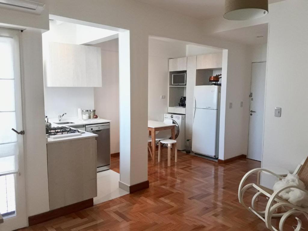 布宜诺斯艾利斯F&F Altos de Barracas的厨房配有桌子和白色冰箱。