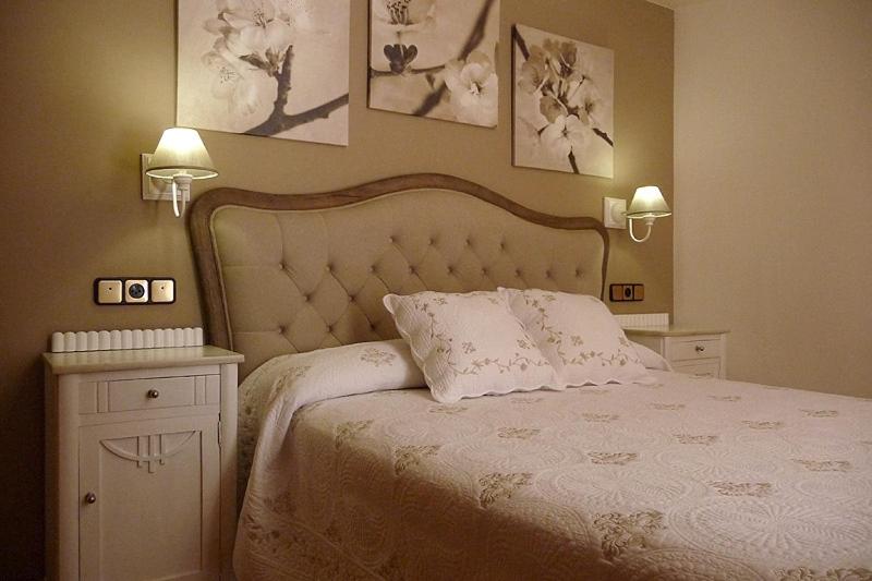 别尔萨Hostal Vidaller旅馆的卧室配有白色床,墙上挂有两盏灯