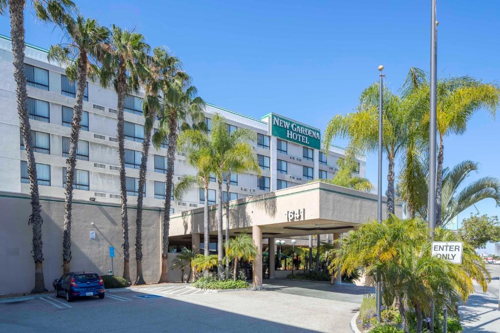 加迪纳市新加迪纳酒店的一座拥有棕榈树和街道标志的酒店大楼