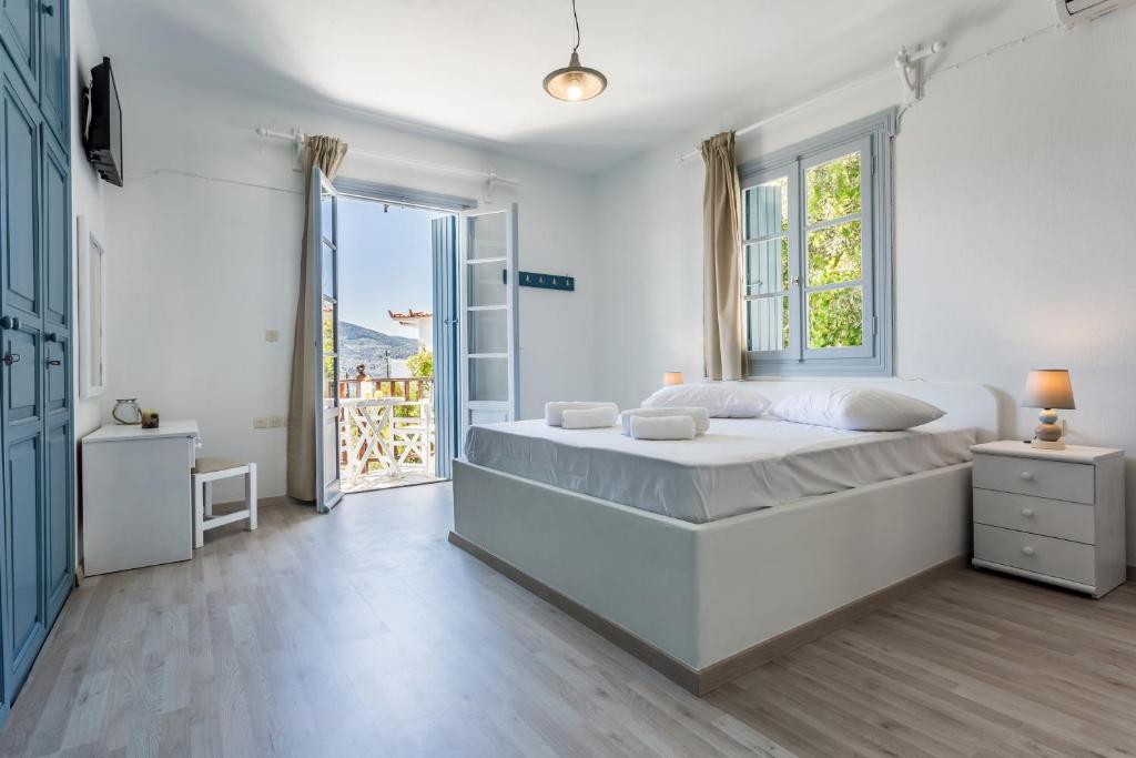 斯科派洛斯Studios Andromache的白色的卧室设有一张大床和一个窗户
