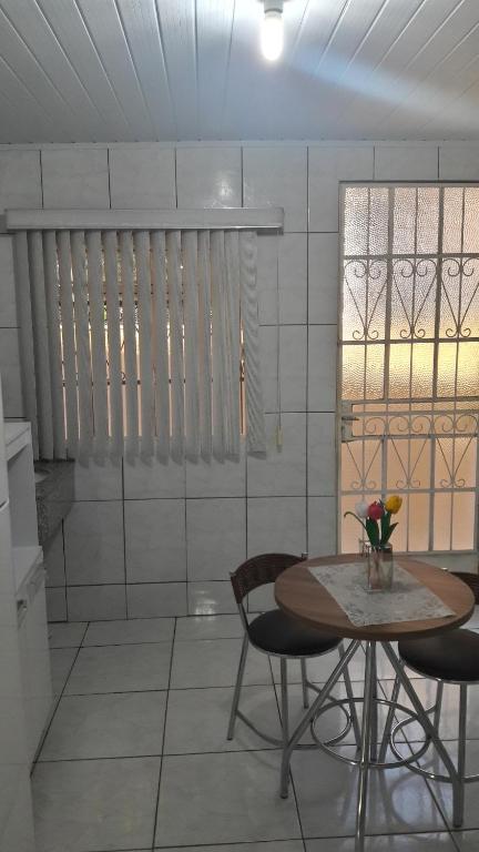 伊瓜苏Apartamento temporário Vila Yolanda的一间带桌椅和窗户的用餐室