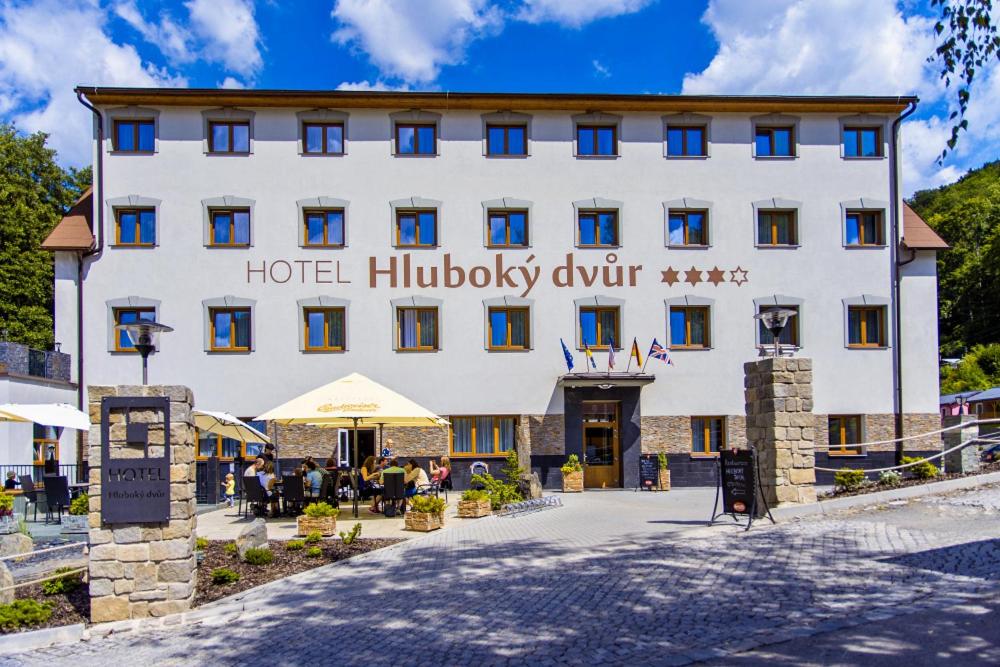 Hrubá VodaWellness Hotel Hluboký Dvůr的一座白色的大建筑,带有酒店理论驱动器