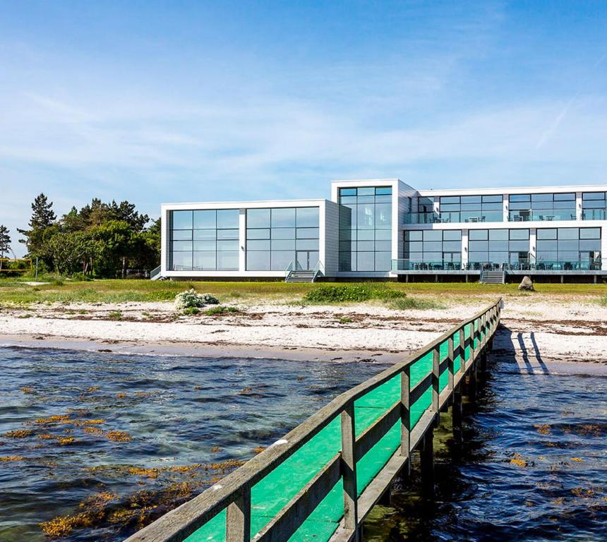 尼堡斯托贝尔特西纳图尔酒店及会议中心的海滩上的一座建筑,靠近一片水域
