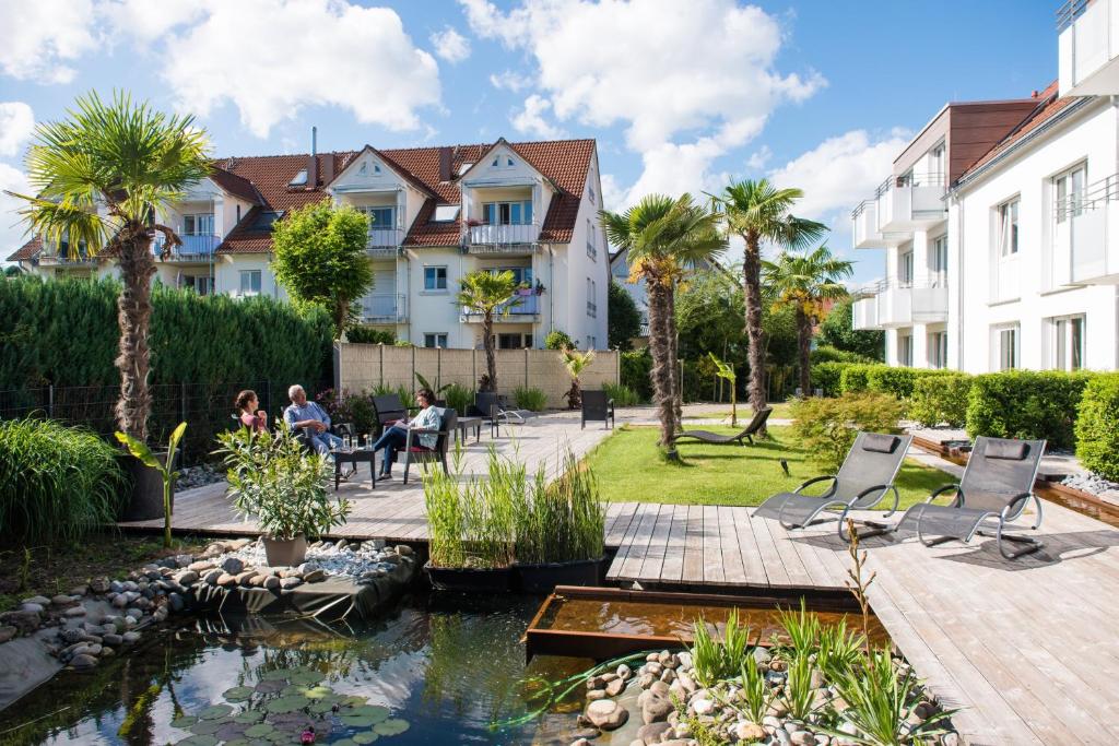 康斯坦茨Hotel Volapük的一个带池塘和建筑的花园