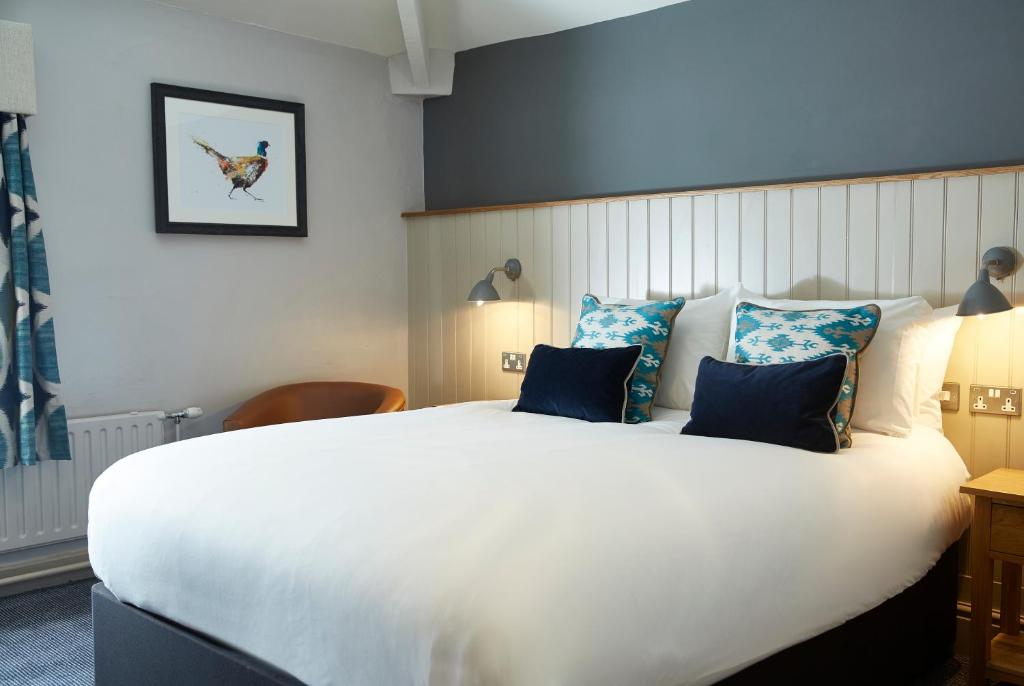 乔利Hartwood Hall by Greene King Inns的卧室配有带蓝色枕头的大型白色床