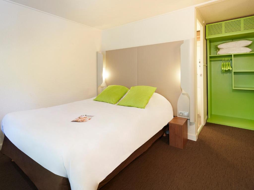 奥尔良钟楼奥尔良苏尔斯酒店的一间卧室配有一张绿色的大白色床。
