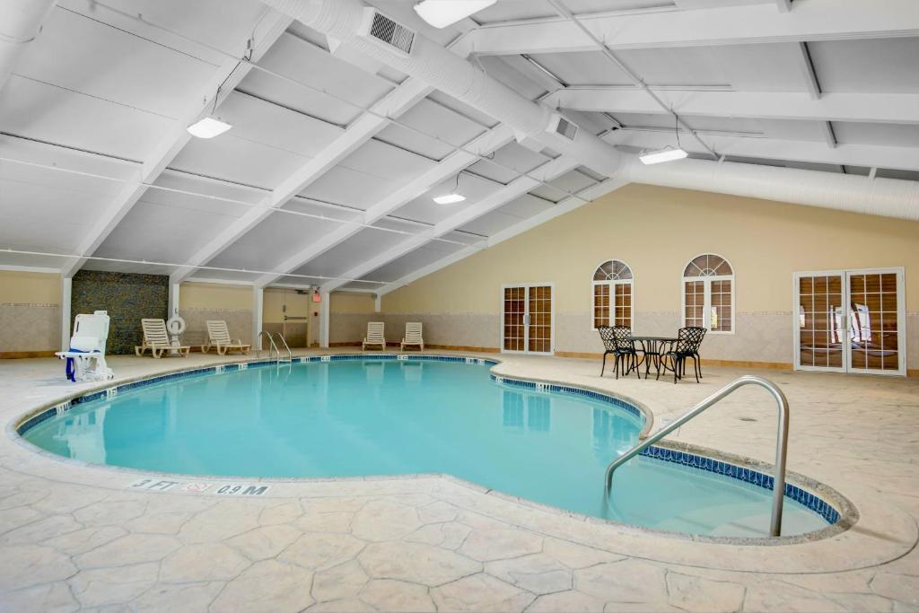 汤姆斯河汤姆斯河泽西河岸戴斯酒店的大房间设有一个大型游泳池,配有桌椅