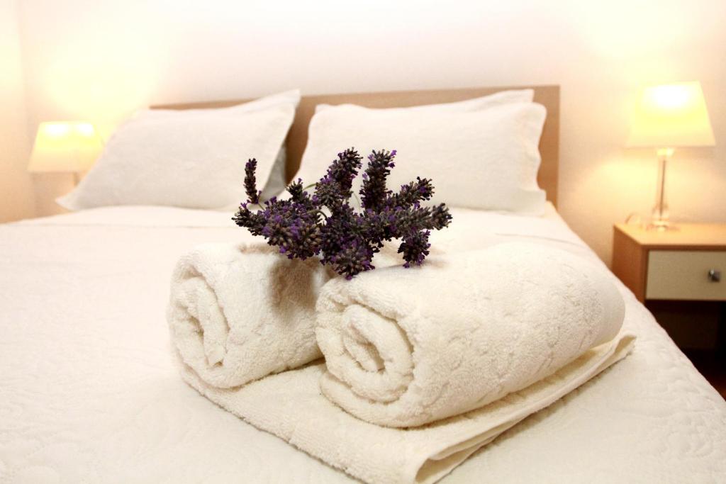 特罗吉尔Apartmani Murtilica的一张带白色毛巾和一束鲜花的床