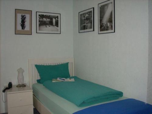 Oberthal苏尔埃施酒店的卧室配有一张绿色床,墙上挂有图片